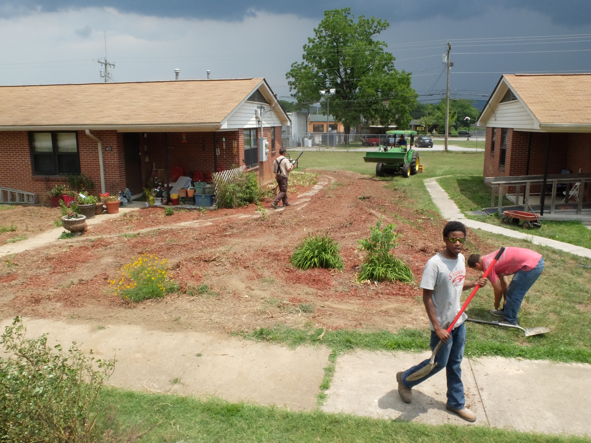 Dirt work continues Tuesday as a South Pittsburg Housing Authority crew works to restore the lawn at 103 Elm Ave. where the resident had a flower garden that encompassed the entire property.