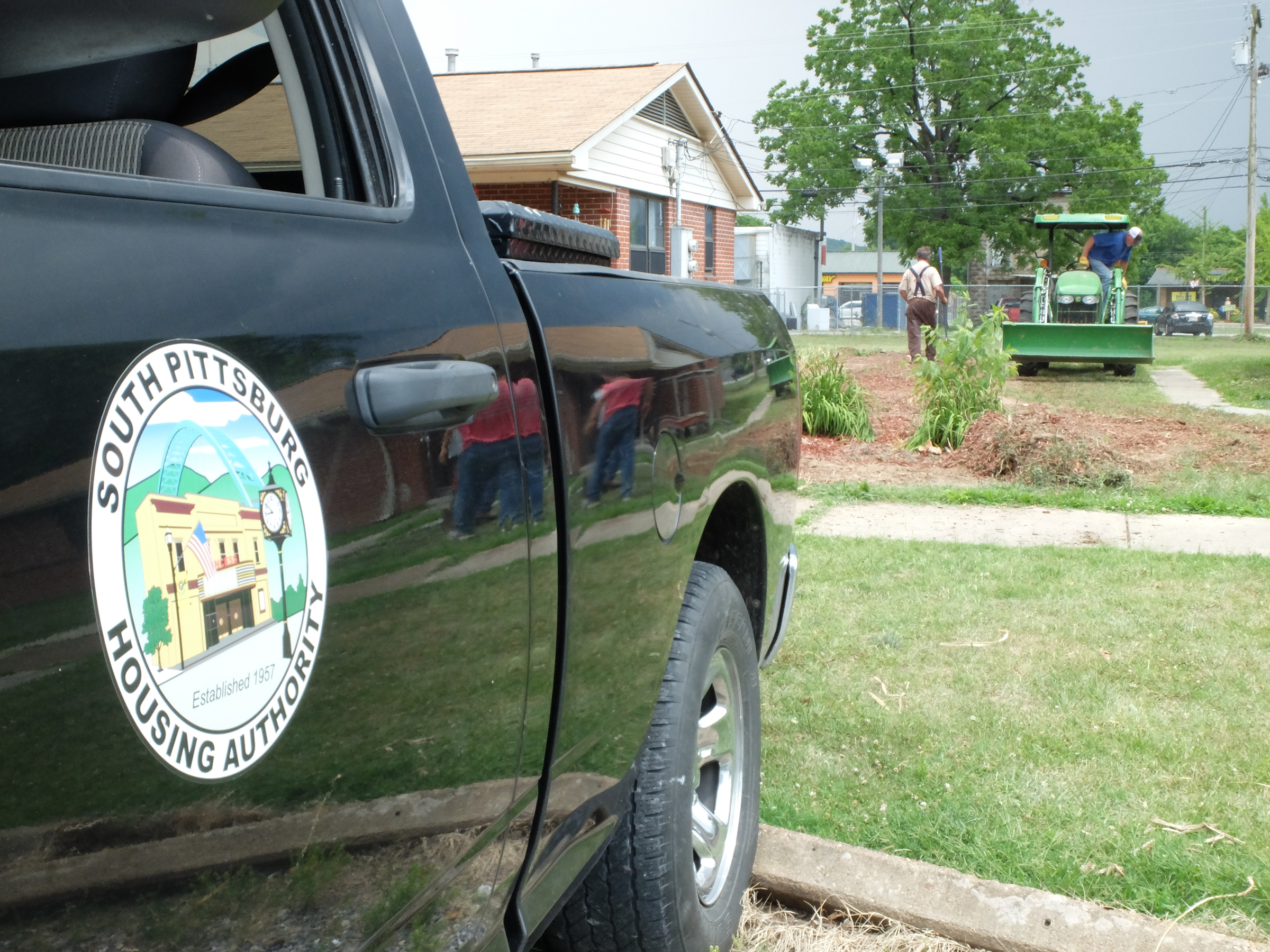 Dirt work continues Tuesday as a South Pittsburg Housing Authority crew works to restore the lawn at 103 Elm Ave. where the resident had a flower garden that encompassed the entire property.