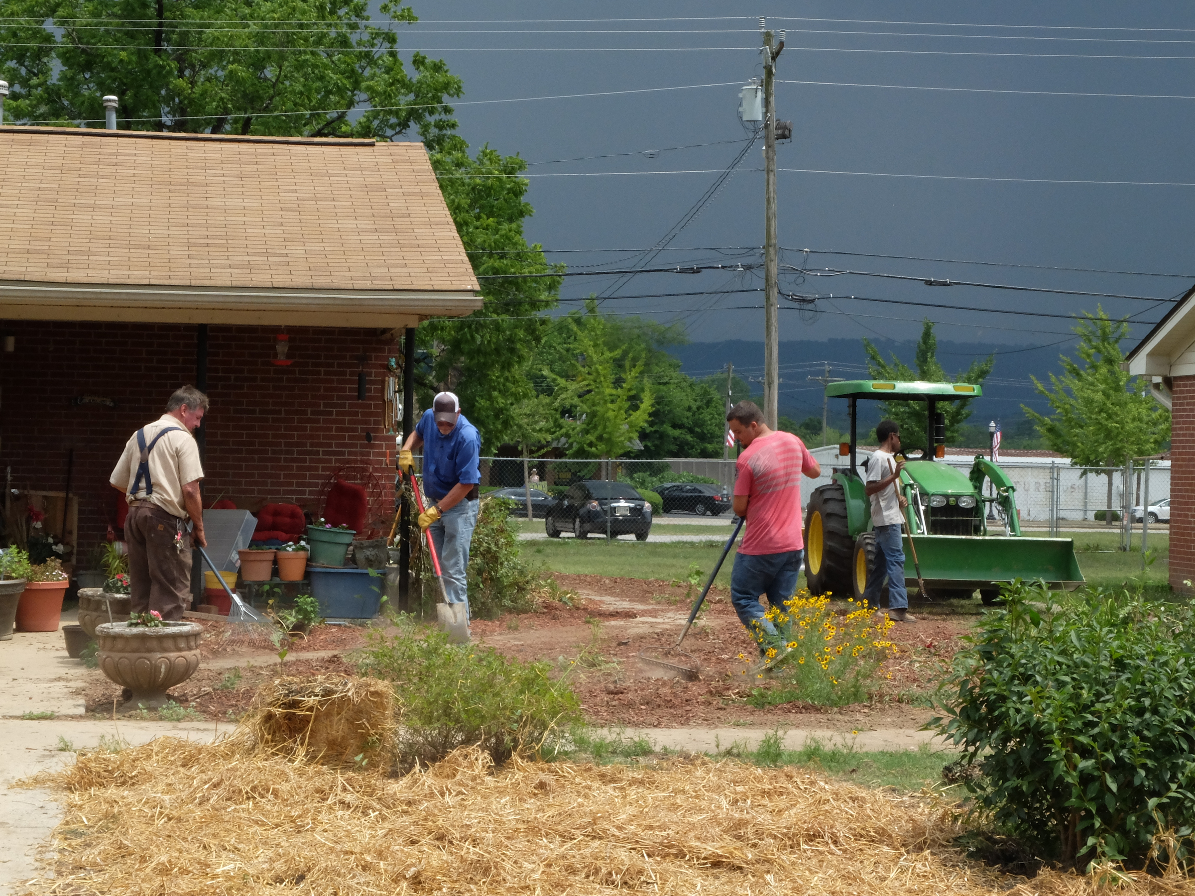 Phillip Smith, second from left, maintenance manager for the South Pittsburg Housing Authority, works with his crew to restore the yard at 103 Elm Ave. where the resident had a flower garden that encompassed the entire property.