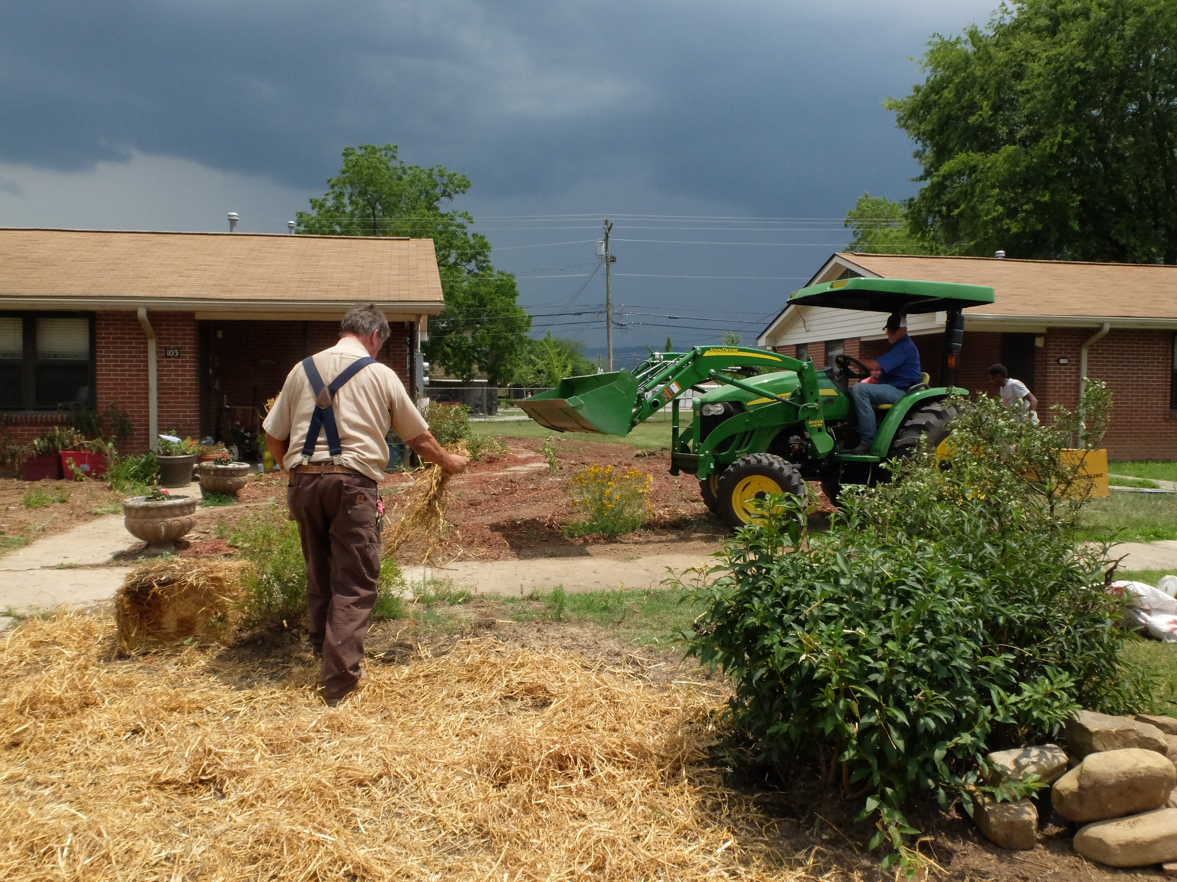 Phillip Smith, on the tractor at right, and his crew work to restore the yard at 103 Elm Ave. where the resident had a flower garden that encompassed the entire property. The four man crew are from the South Pittsburg Housing Authority.