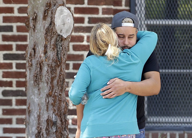 
              Family members of victims of the Orlando nightclub shooting hug outside a family reunification center set up at the Beardall Senior Center, Monday, June 13, 2016, in Orlando, Fla. (AP Photo/Alan Diaz)
            