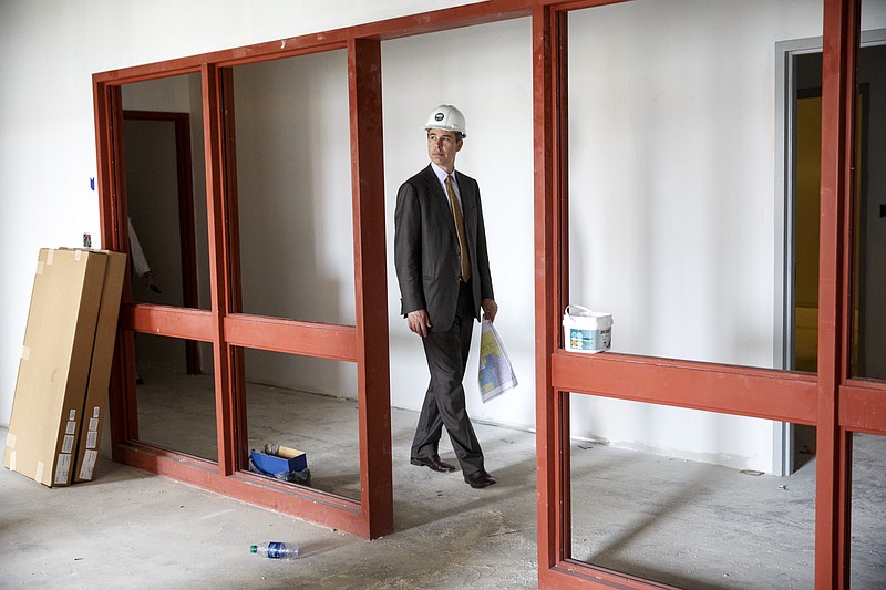 Mayor Andy Berke walks past openings for office windows during a tour by city officials of the future Family Justice Center on Wednesday, June 15, 2016, in Chattanooga, Tenn. When completed, the center will offer services to victims of domestic violence.