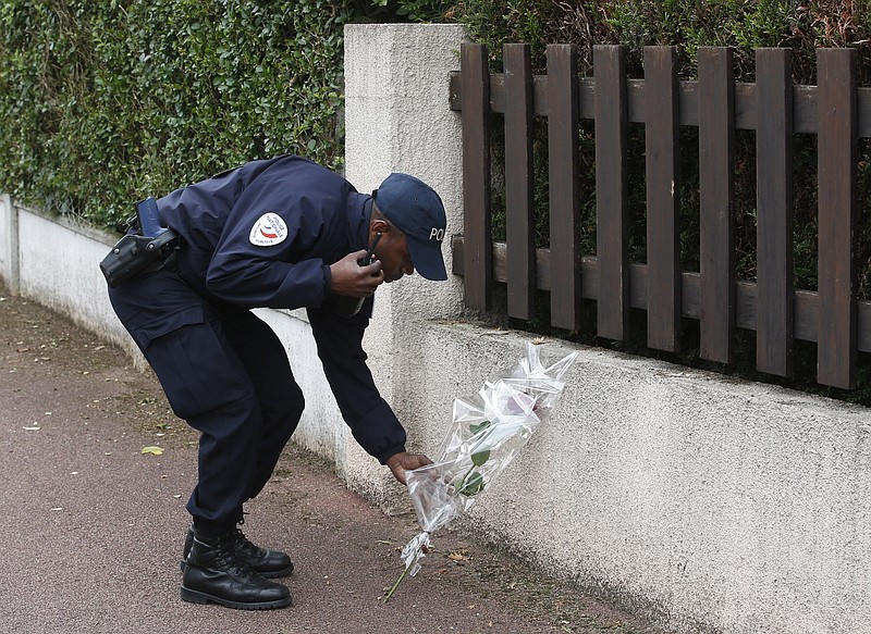 
              A French police officer lays flowers while paying tribute to his colleagues killed in a knife attack near their home in Magnanville, west of Paris, France, Tuesday, June 14, 2016. French President Francois Hollande says that the stabbing attack that left two police officials dead was "incontestably a terrorist act." (AP Photo/Thibault Camus)
            