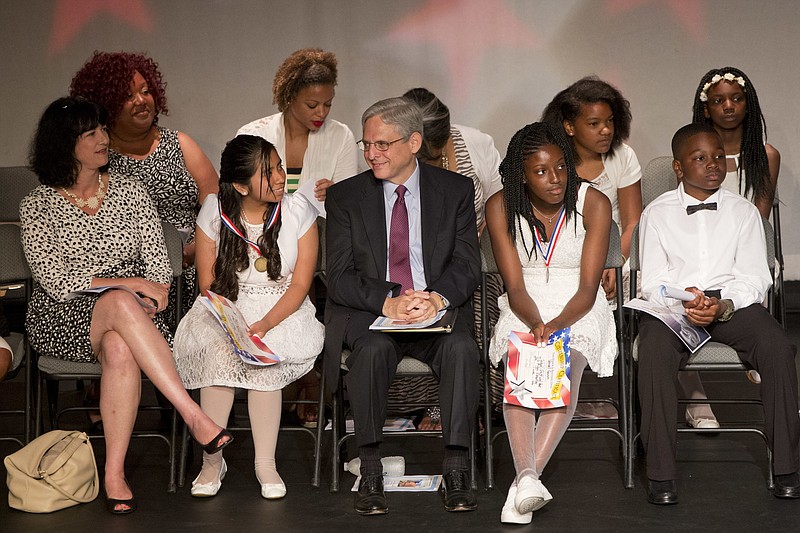 
              Merrick Garland,  President Barack Obama's choice to fill the Supreme Court vacancy,  center, congratulates Jenifer Morales-Garcia, left, after Morales-Garcia and Vernell Garvin, right, both fifth graders who Garland tutors, were awarded medals for math during the graduation ceremony for J.O. Wilson Elementary School, Wednesday, June 15, 2015, at the Atlas Performing Arts Center in Washington. Garland has tutored students at the school over the past 18 years. (AP Photo/Jacquelyn Martin)
            