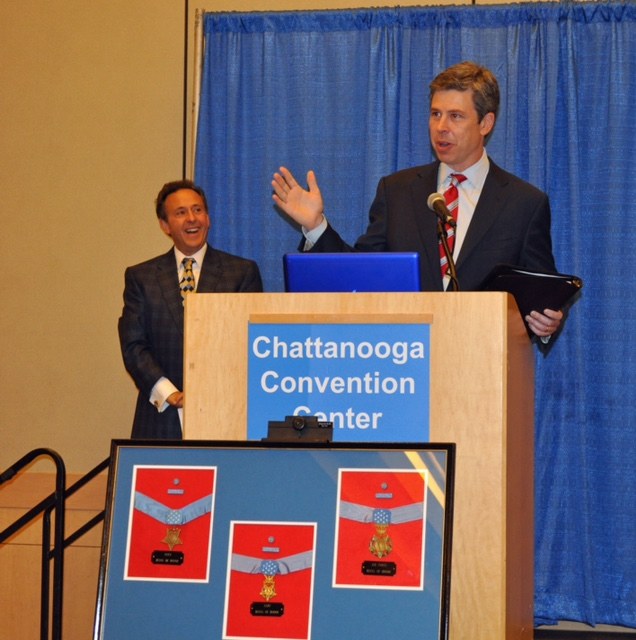 Jed Mescon, master of ceremonies, left, listens to Chattanooga Mayor Andy Berke.