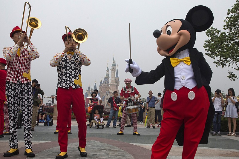 Mickey Mouse entertains visitors on the opening day of the Disney Resort in Shanghai, China, Thursday, June 16, 2016. Walt Disney Co. opened its first theme park in mainland China on Thursday at a ceremony that mixed speeches by Communist Party officials, a Chinese children's choir and actors dressed as Sleeping Beauty and other Disney characters. (AP Photo/Ng Han Guan)