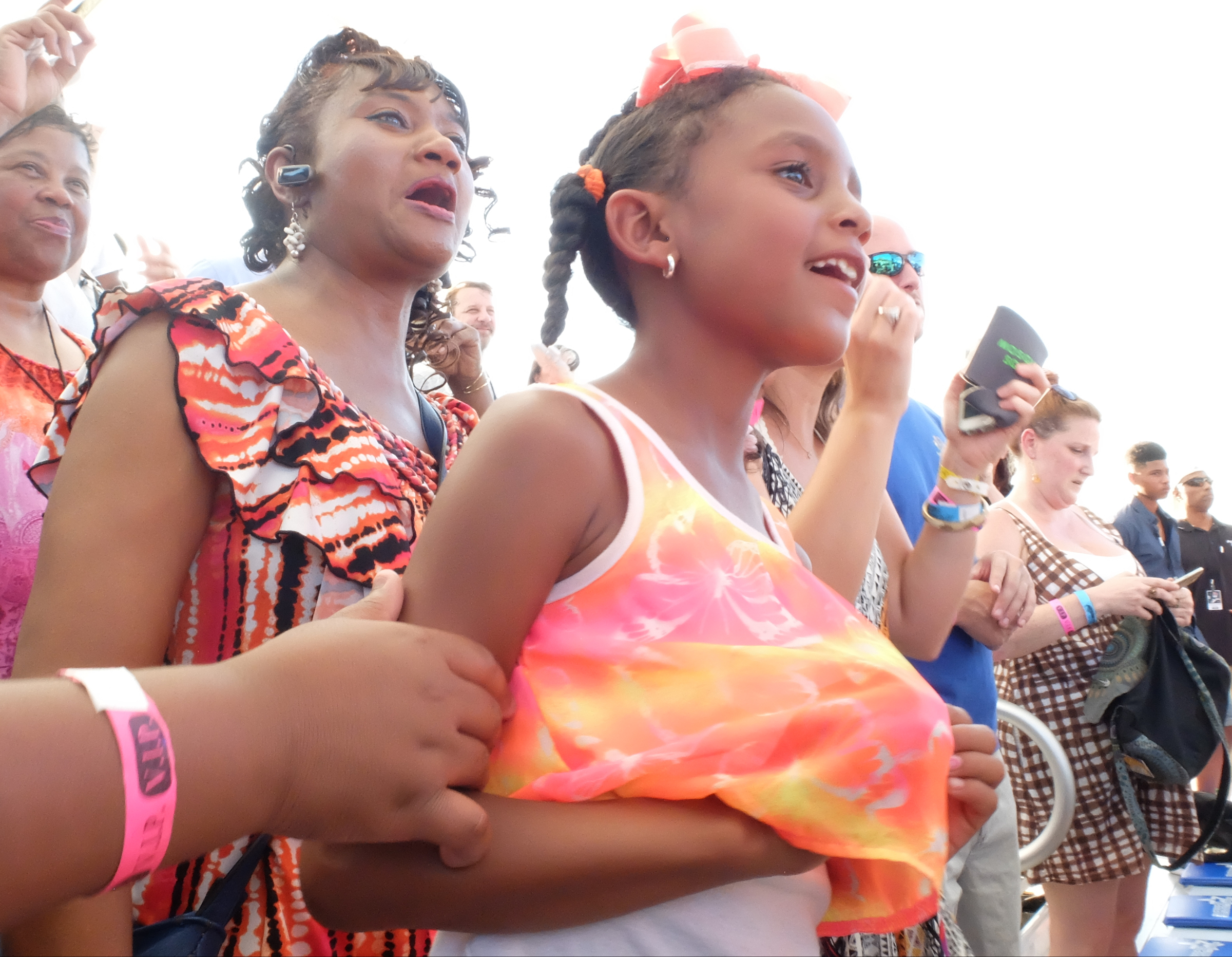 DeKendra Clark, right, smiles as Deidre Clark, left, watch the first song performed by Salt N Pepa on the side of the Coca-Cola Stage Thursday evening.