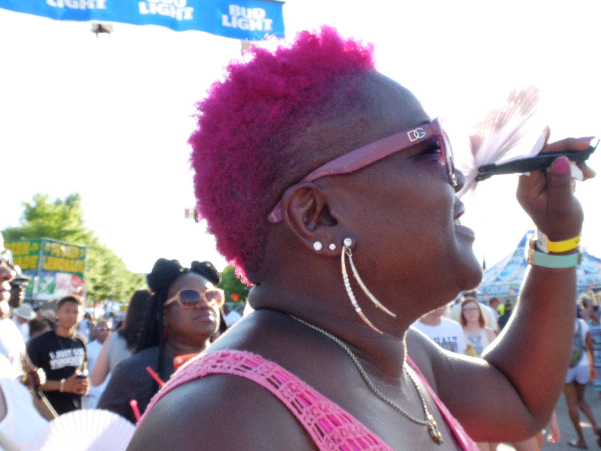 Shirley Porch waves her fan to stay cool late Thursday during the Salt N Pepa performance at Riverbend.