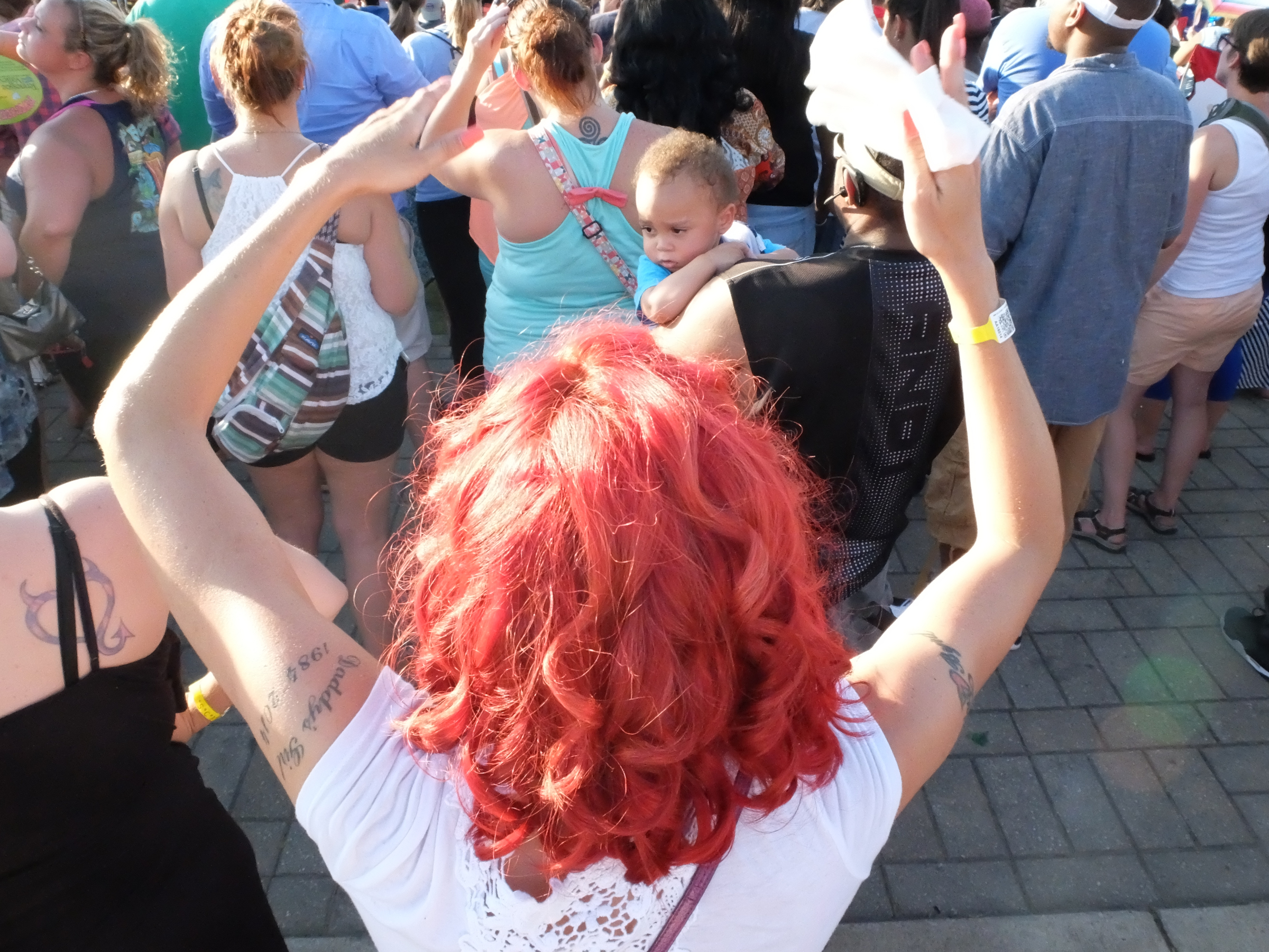 Little Tayvon Clanton, 1, looks around at all the dancing people around him as Salt N Pepa perform on the Coca-Cola Stage Thursday evening.