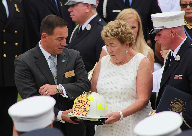 
              Theresa Stack holds the helmet of her husband, FDNY Battalion Chief Lawrence Stack, following his funeral on Friday, June 17, 2016, in St. James, N.Y. Friday would have been the couple's 49th wedding anniversary. Stack died in the terrorist attacks of Sept. 11, 2001. (AP Photo/Frank Eltman)
            