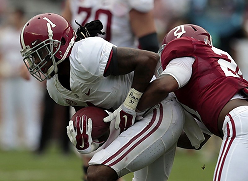 Alabama wide receiver Chris Black (1) catches a pass as he is tackled by Alabama defensive back Maurice Smith (21) during the second half of Alabama's spring NCAA college football game, Saturday, April 18, 2015, in Tuscaloosa, Ala. (AP Photo/Butch Dill)