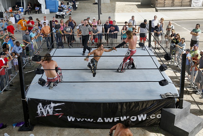 Wrestlers with AWF wrestling compete in a ring beneath the Olgiati Bridge on the final day of the Riverbend Festival at Ross's Landing on Saturday, June 18, 2016, in Chattanooga, Tenn. AWF Wrestling from Ringgold, Ga., brought live wrestling to the final day of the festival.