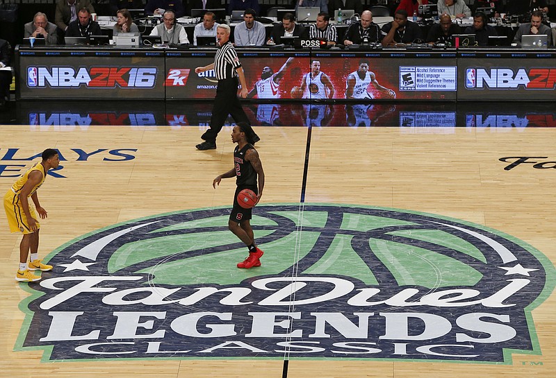 
              FILE - In this Nov. 24 2015, file photo, North Carolina State guard Anthony Barber dribbles the ball across the FanDuel logo during an NCAA college basketball game in the Legends Classic in New York. Although legislators in Albany voted to regulate and tax fantasy sports matches on Saturday, June 18, 2016, the industry still faces uncertainty in New York State. (AP Photo/Kathy Willens, File)
            