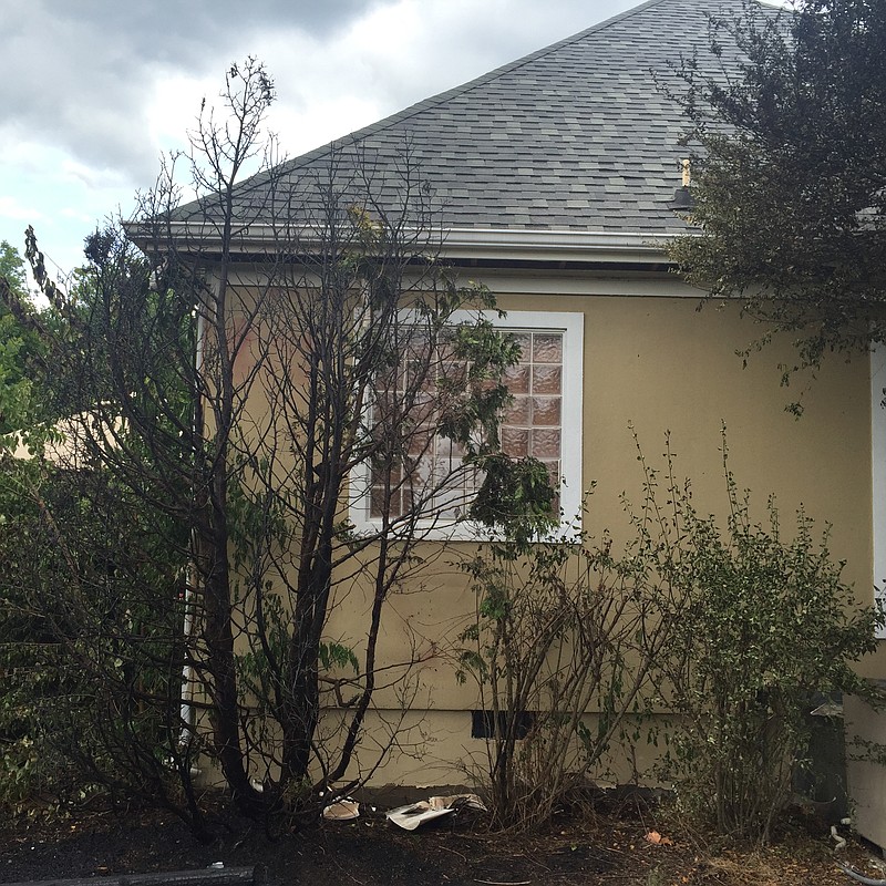 A Saturday afternoon fire that started around a backyard playground spread toward this house. (Photo by Battalion Chief Rick Boatwright)