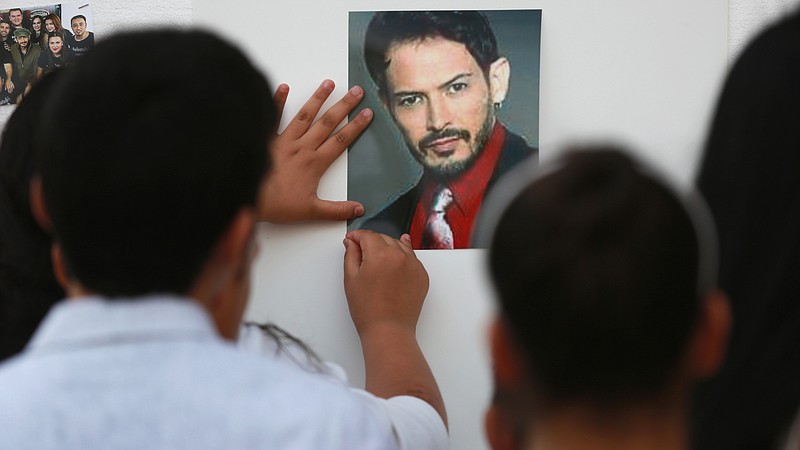 
              In this Saturday, June 18, 2016 photo, a child posts a photograph of Alejandro "Jano" Fuentes outside Tras Bambalinas music school during a memorial in Chicago. The singer who appeared on the Mexican version of "The Voice" in 2011 has died after he was shot in an ambush while celebrating his birthday with friends. (John J. Kim/Chicago Tribune via AP) MANDATORY CREDIT CHICAGO TRIBUNE; CHICAGO SUN-TIMES OUT; DAILY HERALD OUT; NORTHWEST HERALD OUT; THE HERALD-NEWS OUT; DAILY CHRONICLE OUT; THE TIMES OF NORTHWEST INDIANA OUT; TV OUT; MAGS OUT; NO SALES
            