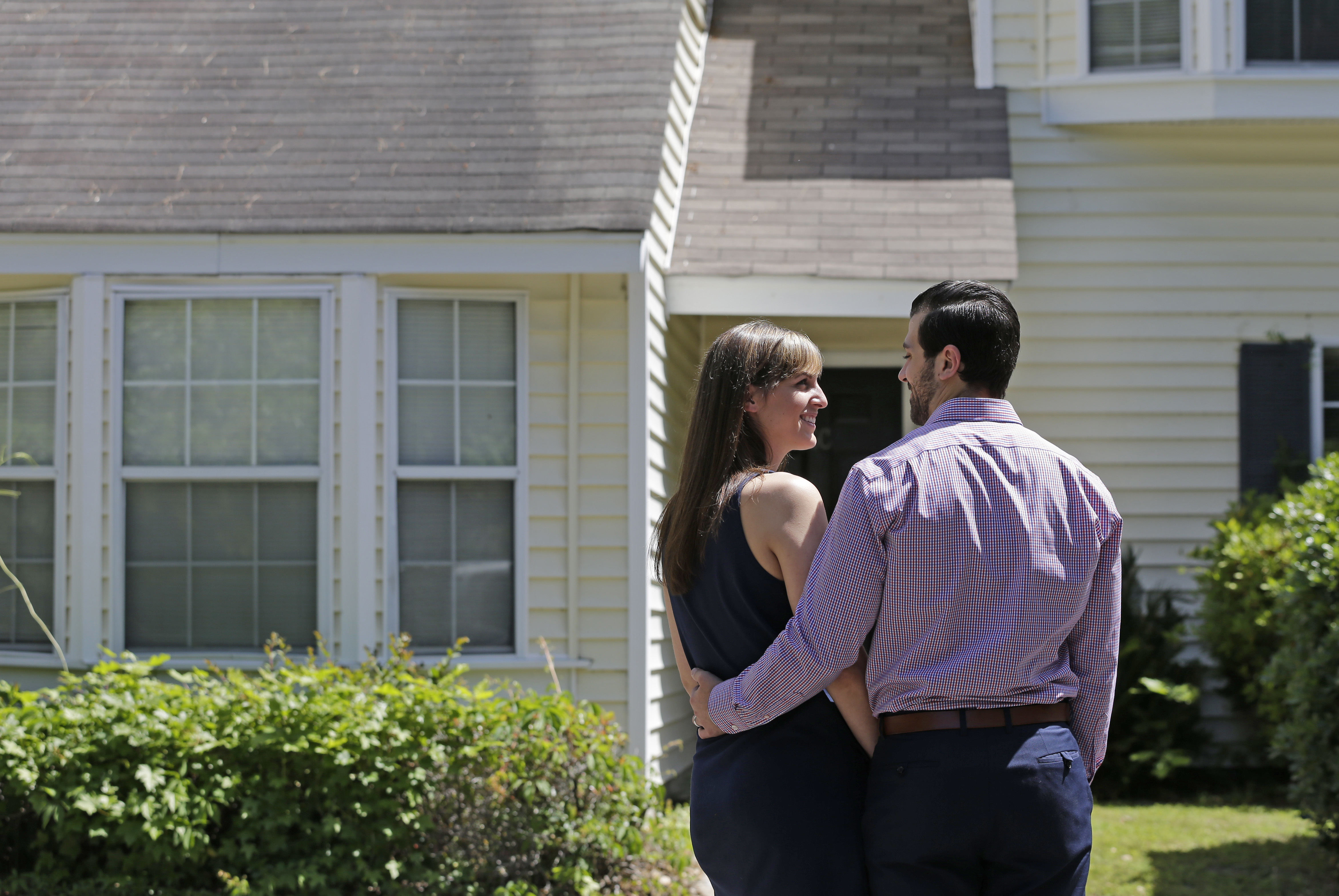 In this Tuesday, April 19, 2016, photo, Joe Fabie, right, and his wife, Christi, pose for a photo in front of their rental home in Charleston, S.C. The Fabies left Mount Pleasant, S.C., to rent somewhere cheaper. Both have law school debt and are saving to buy a home. (AP Photo/Chuck Burton)