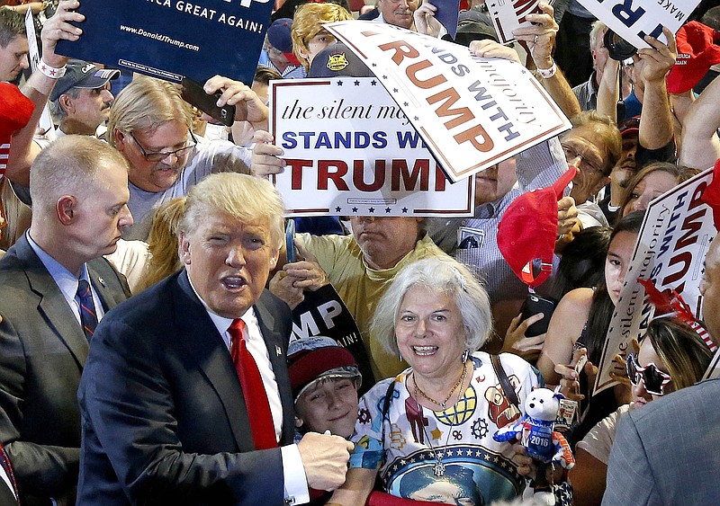 
              Republican presidential candidate Donald Trump, left, shouts to Secret Service agents that supporter Diana Brest, right, had been waiting in line since 2 a.m. to see the candidate speak at a rally Saturday, June 18, 2016, in Phoenix. (AP Photo/Ross D. Franklin)
            
