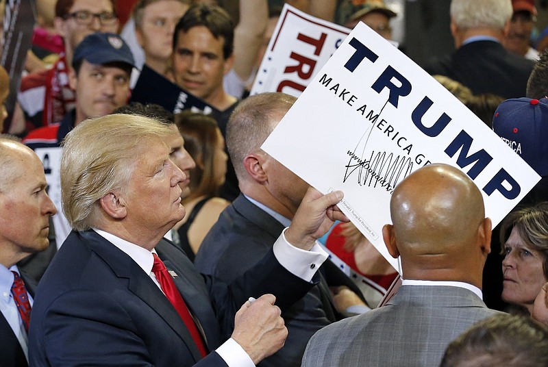 
              Republican presidential candidate Donald Trump signs autographs after speaking at a rally Saturday, June 18, 2016, in Phoenix. (AP Photo/Ross D. Franklin)
            