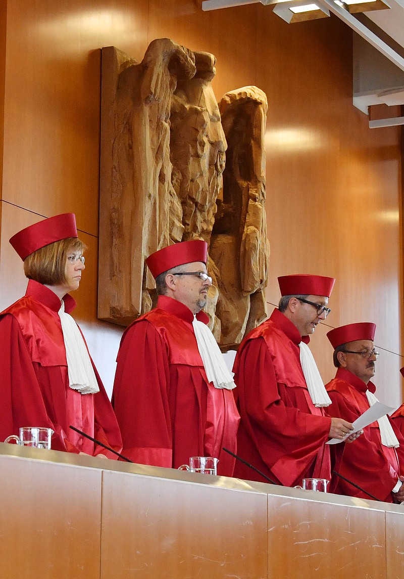 
              Judges of the constitutional court in  Karlsruhe, Germany, from left:  Monika Hermanns, Peter Huber, Andreas Vosskuhle the President of the court,  and  Herbert Landau announce their  decision  Tuesday June 21, 2016.  Germany's constitutional court has rejected a challenge to a European Central Bank bond-buying program credited with helping keep the euro currency union from breaking up in 2012. The court in Karlsruhe said Tuesday that the ECB had not exceeded its legal powers and rejected arguments from legislators and a citizens' group that the offer to purchase government bonds of troubled countries violated German law.  (Uli Deck/dpa via AP)
            