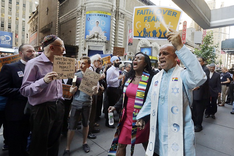 
              Clergy leaders with PICO (People Improving Communities through Organizing) Action Fund and their local federation, Faith in New York, demonstrate outside the hotel in New York's Times Square, Tuesday, June 21, 2016, where Republican presidential candidate Donald Trump is scheduled to meet evangelical clergy. (AP Photo/Richard Drew)
            
