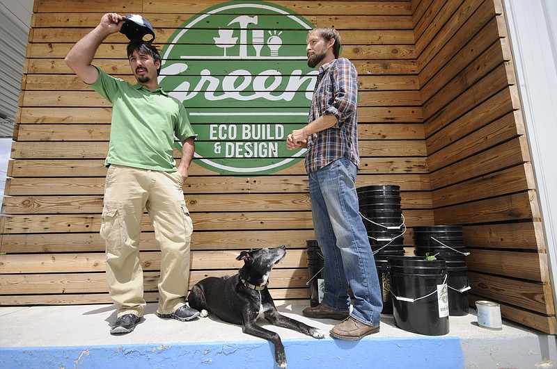 Green's Eco Build & Design owners Tyler Smith, left, and Sam Young stand beside the remaining recycled plastic buckets they have available at their new business on Riverside Drive. (Photo: Tim Barber)