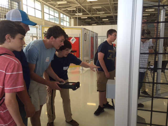 Mechatornics Akademie students working together operating the Fanuc Robot in Caleb Bagby's robotics session this summer.