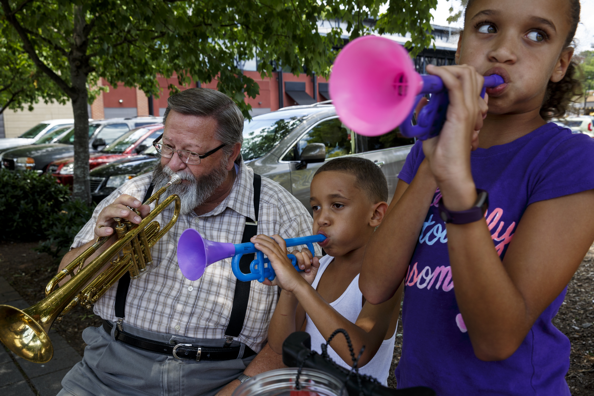 Randy Croy, left, plays trumpet along with Jaxon McCord, center, and Jazalyn McCord, whom got their plastic trumpets from Croy.