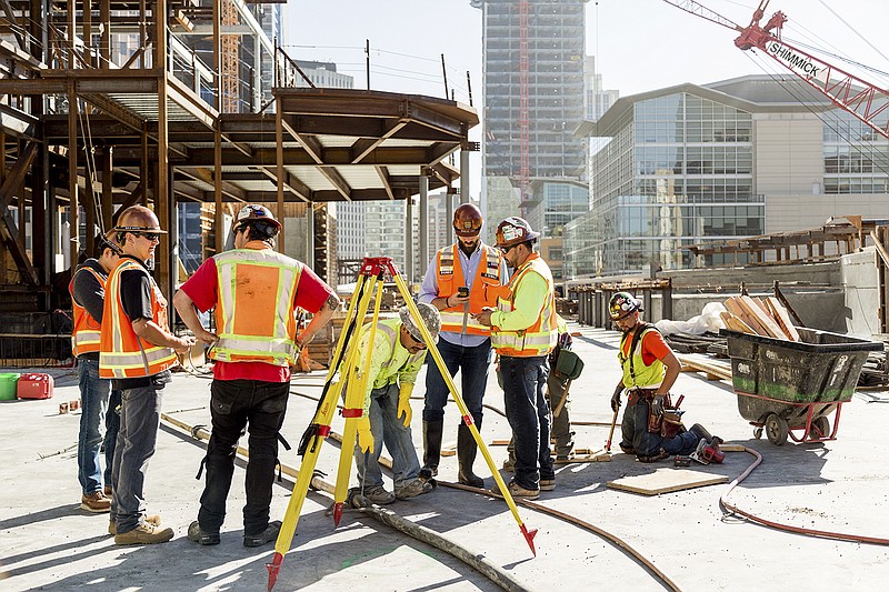 Drew DeWalt, a co-founder of Rhumbix,  veteran focused startup, center, gives Jose Luis Garcia, a foreman, an introduction to the company's software which helps manage construction jobs, in San Francisco, June 21, 2016.  Some entrepreneurial veterans are adapting tools and strategies they learned during their service for civilian applications, and some have been inspired to start companies to address problems they witnessed on the battlefield. (Jason Henry/The New York Times)