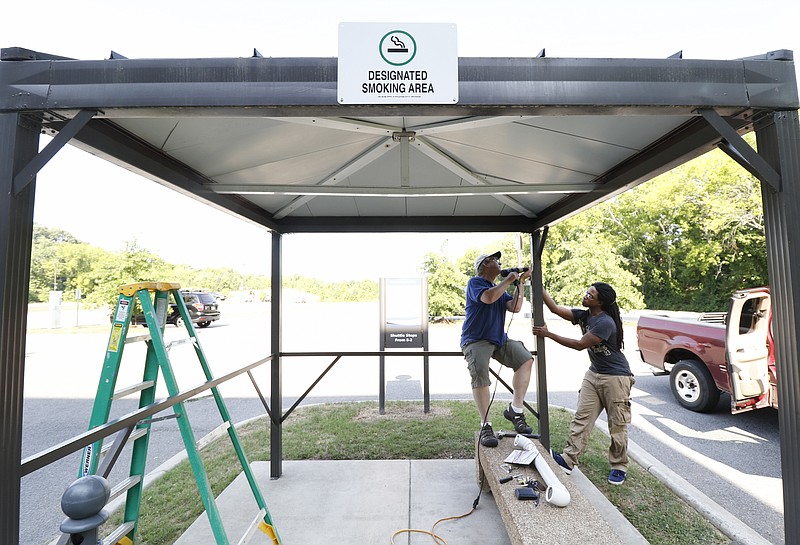 Staff Photo by Dan Henry / The Chattanooga Times Free Press- 6/22/16. Dr. Michael Pugh and Ajani Bakari install a solar and capacitor based phone charger on Wednesday, June 22, 2016, at a pavilion previously designated for smokers on the Chattanooga State campus. 
