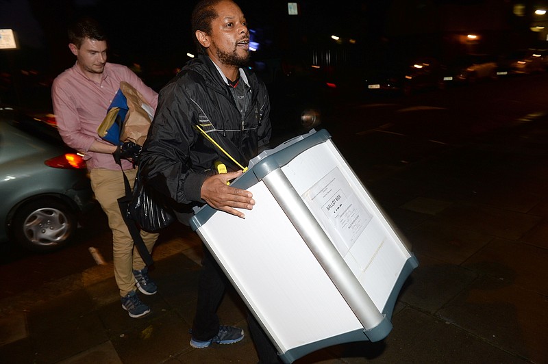 A ballot box is carried into the Royal Horticultural Halls in London as counting gets underway in the referendum on the UK's membership of the European Union, Thursday June 23, 2016. On Thursday Britain votes in a national referendum on whether to stay inside the EU. (Anthony Devlin / PA via AP)