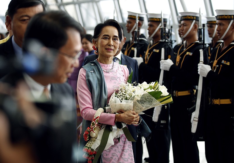 
              Myanmar Foreign Minister Aung San Suu Kyi, center, walks past a Thai honor guard as she arrives at the Suvarnabhumi Airport, Thursday, June 23, 2016, in Bangkok, Thailand. Suu Kyi is on an official three day visit to Thailand from June 23-25, 2016. (Narong Sangnak/Pool Photo via AP)
            