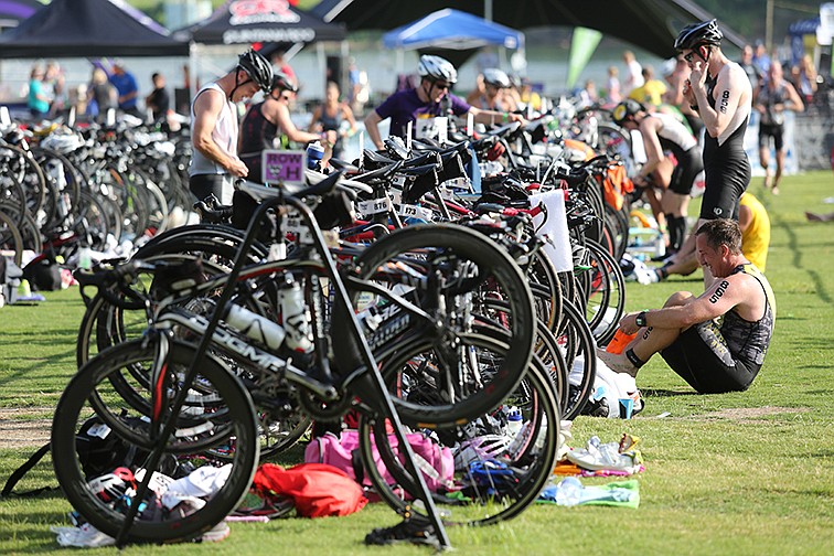 Triathletes make the transition from the swimming portion of the Chattanooga Waterfront Triathlon into the bicycling portion of the race on June 29, 2014.