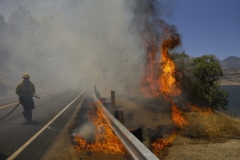 
              A firefighter battles a wildfire burning along Highway 178, Friday, June 24, 2016 in Lake Isabella, Calif. The wildfire that roared across dry brush and trees in the mountains of central California gave residents little time to flee as flames burned homes to the ground, propane tanks exploded and smoke obscured the path to safety. (AP Photo/Jae C. Hong)
            