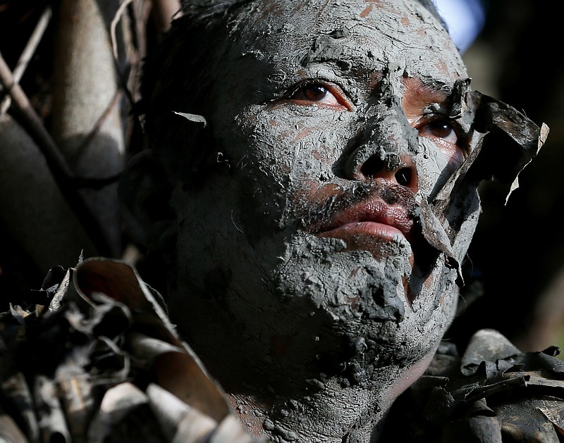 
              A villager, donning capes mostly of dried banana leaves and covered in mud, attends a mass in a bizarre annual ritual to venerate their patron saint, John the Baptist, Friday, June 24, 2016 at Bibiclat, Aliaga township, Nueva Ecija province in northern Philippines. The "Taong Putik" or "mud people" festival in Bibiclat village dates back to the Japanese occupation of the Philippines in the 1940s. (AP Photo/Bullit Marquez)
            