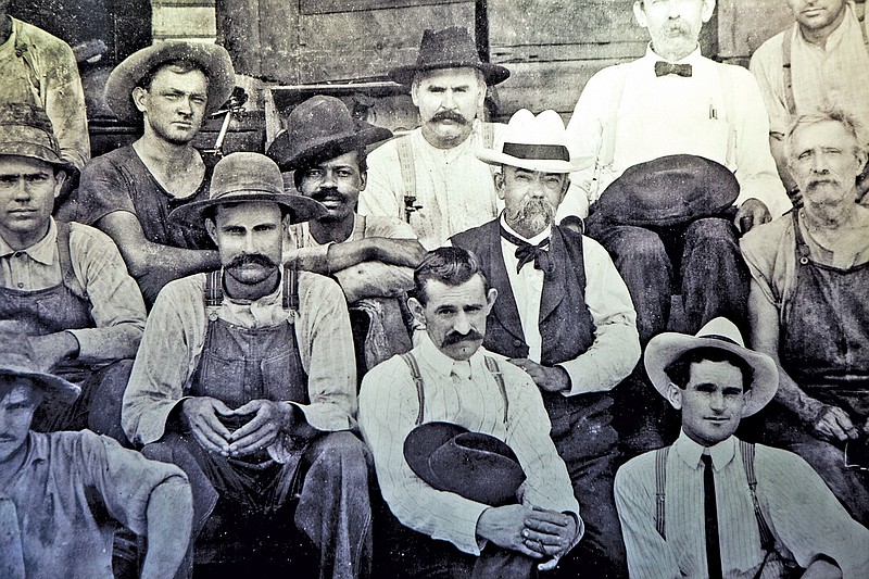 In the center of this undated handout photo from Jack Daniel's sits Jack Daniel himself in the white hat. To his right is a man who could be a son of Nearis Green. Daniel didn't learn distilling from Dan Call — preacher, grocer and distiller — but from Green, one of Call's slaves.
