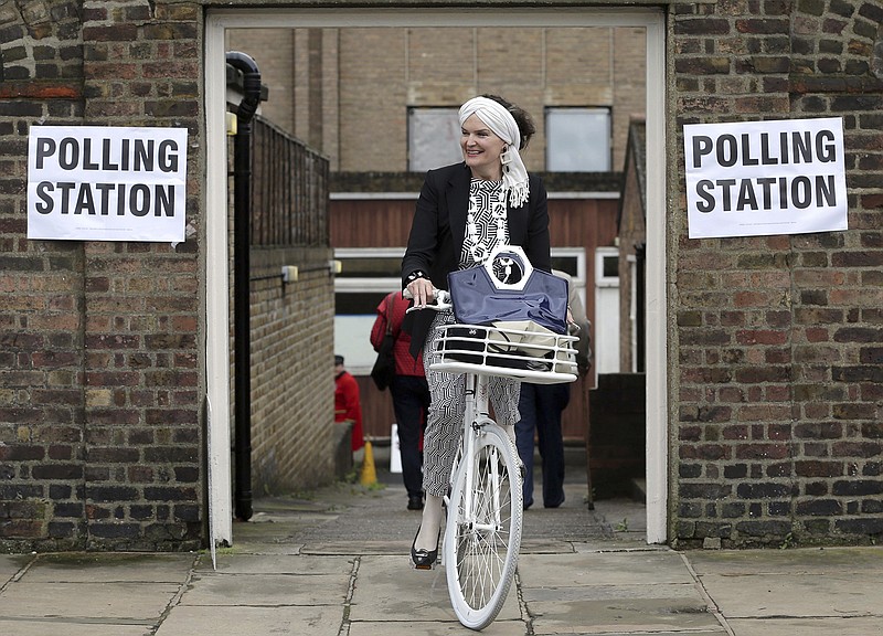 A woman on a bicycle leaves a polling station near to the Royal Chelsea Hospital, London Thursday June 23, 2016. Voters in Britain are deciding Thursday whether the country should remain in the European Union. (Daniel Leal-Olivas/PA via AP) UNITED KINGDOM OUT - NO SALES - NO ARCHIVE