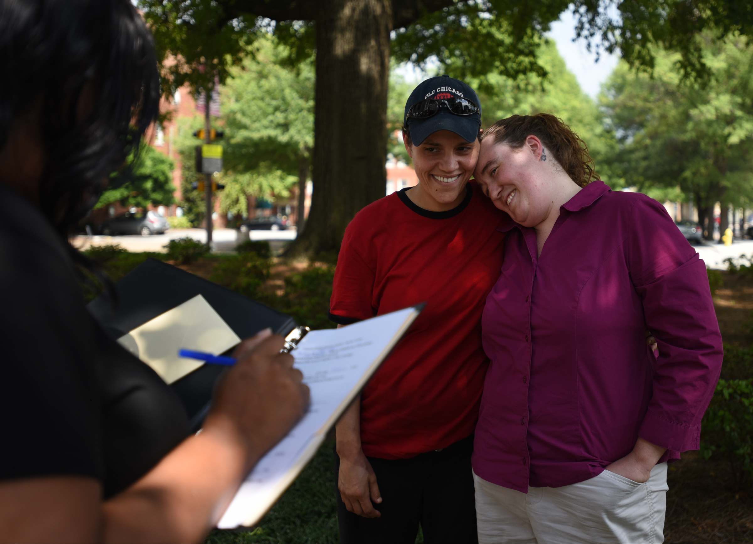 Celebrant Shaun Cox prepares as Rhiannan Pierce, left, and with Phyllis Wood hug before their marriage ceremony Friday, June 26, 2015t at the Hamilton County Courthouse.