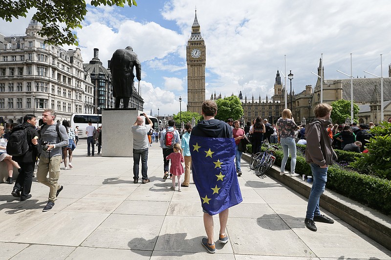 
              A demonstrator wrapped in the EU flag takes part in a protest opposing Britain's exit from the European Union in Parliament Square following yesterday's EU referendum result, London, Saturday, June 25, 2016. Britain voted to leave the European Union after a bitterly divisive referendum campaign. (AP Photo/Tim Ireland)
            