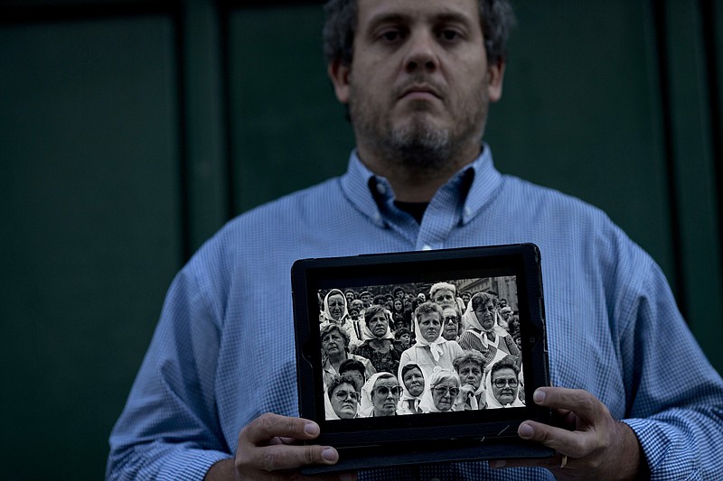 
              In this May 11, 2016 photo, Pedro Sandoval, who was stolen as a baby, poses holding a framed image of the Grandmothers of Plaza de Mayo group, that include both of his biological grandmothers, who helped him recover his true identity, in Buenos Aires, Argentina. Sandoval stopped celebrating Mother's Day, Father's Day and even his own birthday after he found out the truth: The mom and dad he knew growing up had stolen him from his biological parents, who were kidnapped, tortured and never heard from again during Argentina's 1976-1983 military dictatorship. (AP Photo/Natacha Pisarenko)
            