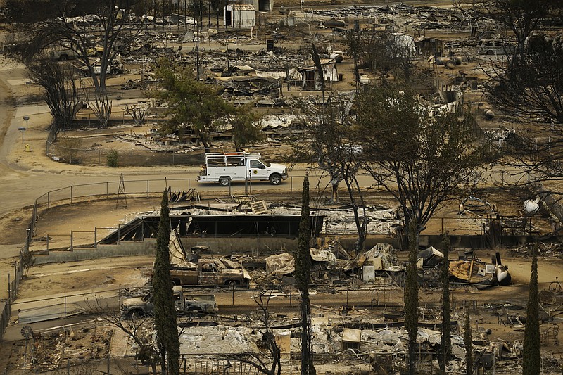 
              A pickup truck passes by the remains of mobile homes devastated by a wildfire, Saturday, June 25, 2016, in South Lake, Calif.  Gov. Jerry Brown declared a state of emergency, freeing up money and resources to fight the fire and to clean up in the aftermath. The Federal Emergency Management Agency also authorized the use of funds for firefighting efforts. (AP Photo/Jae C. Hong)
            