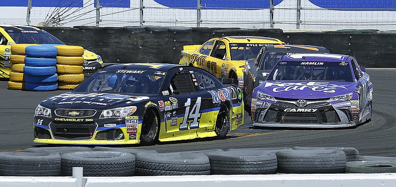 Tony Stewart, left, leads Denny Hamlin through Turn 11 during the NASCAR Sprint Cup Series auto race Sunday, June 26, 2016, in Sonoma, Calif.