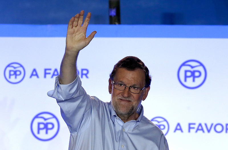 Spain's acting Primer Minister and candidate of Popular Party Mariano Rajoy, waves to his supporters as he celebrates the results of the party during the national elections in Madrid, Spain, Sunday, June 26, 2016.