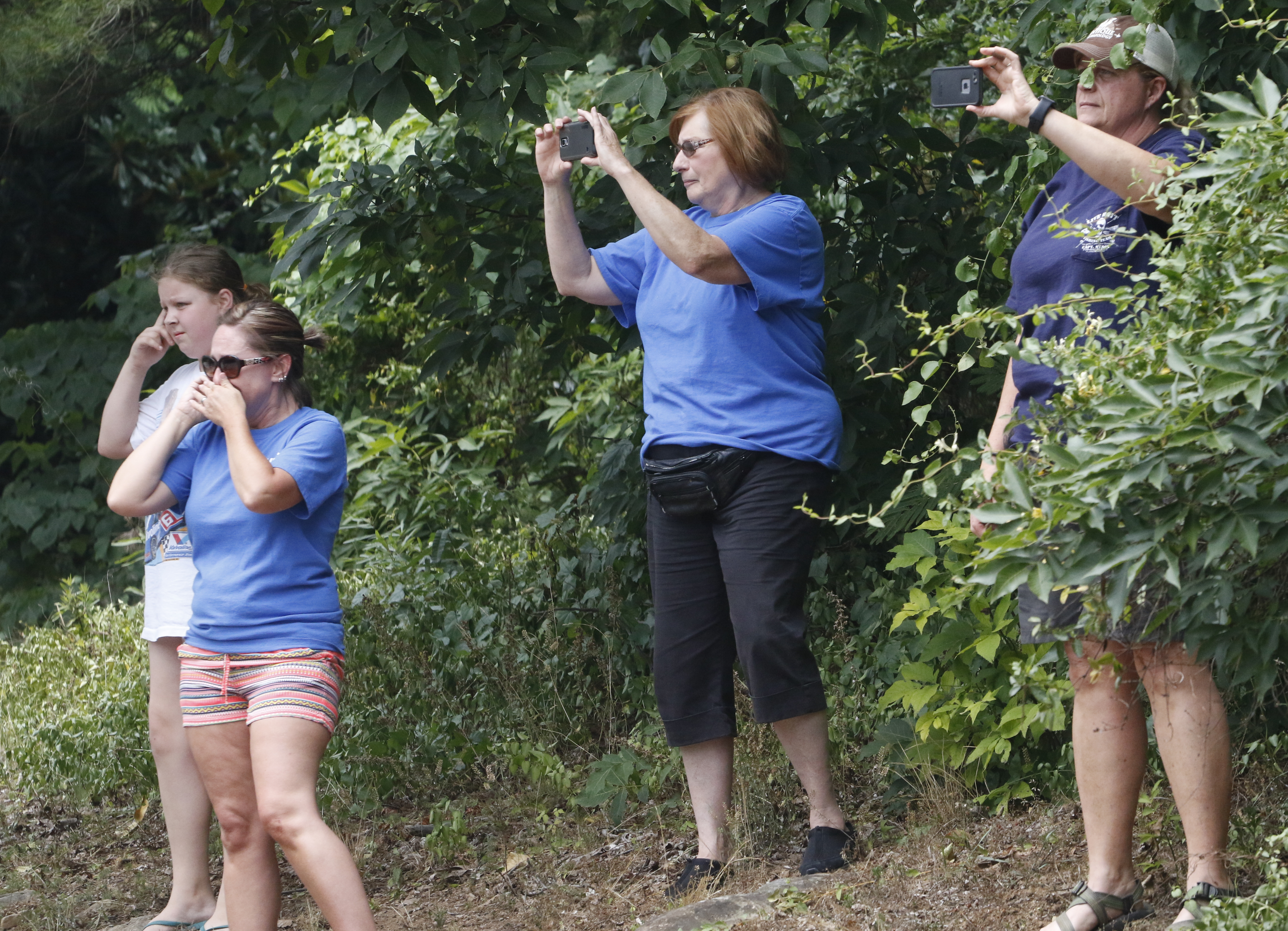 Brandi Hilton, bottom left, becomes emotional as she and others watch D.H.Griffin Wrecking Company workers begin demolition.