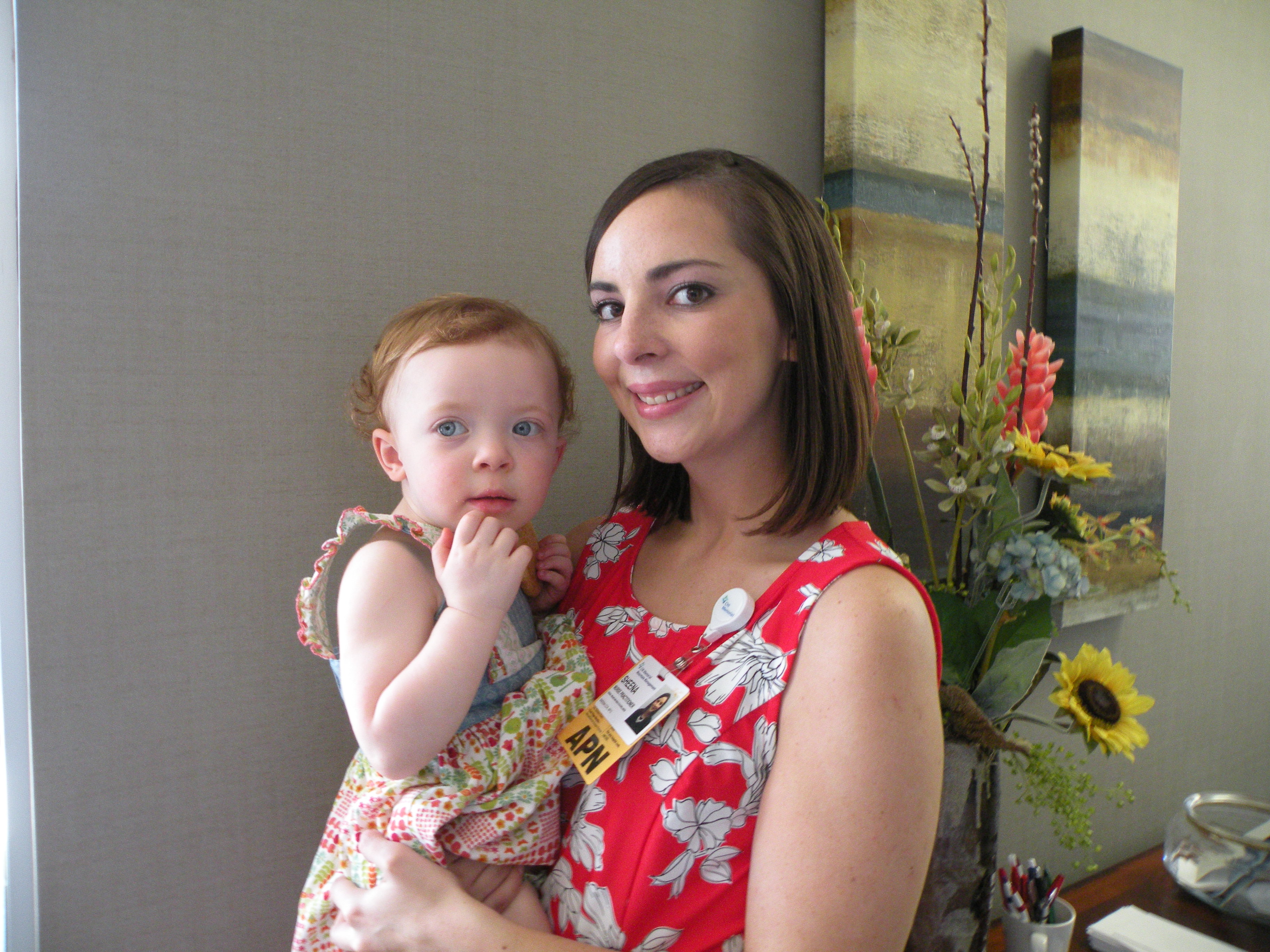 Nurse practitioner Sheena Cox, who joined the practice four months ago, holds daughter Brennen at the party to say farewell to Dr. Justin Cooke.
