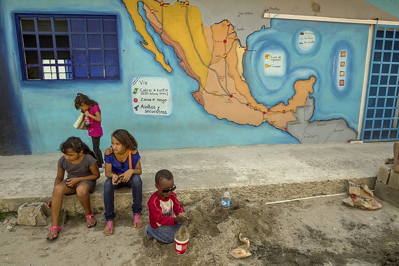 In this 2014 file photo, undocumented migrant children play near a map of Mexico at the 72 migrant shelter in Tenosique, Mexico, July 2, 2014. A U.S.-Mexico deportation policy can mean death for youths targeted by the gangs they fled.