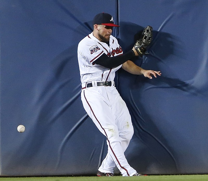 Atlanta Braves center fielder Ender Inciarte bangs into the wall as he chases a ball hit for a single by Cleveland Indians' Jason Kipnis in the seventh inning of a baseball game Monday, June 27, 2016, in Atlanta. (AP Photo/John Bazemore)