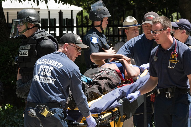 
              Paramedics rush a stabbing victim away on a gurney Sunday, June 26, 2016, after members of right-wing extremists groups holding a rally outside the California state Capitol building in Sacramento clashed with counter-protesters, authorities said. Sacramento Police spokesman Matt McPhail said the Traditionalist Workers Party had scheduled and received a permit to protest at noon Sunday in front of the Capitol. McPhail said a group showed up to demonstrate against them. (AP Photo/Steven Styles)
            