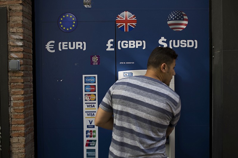 
              FILE - In this Friday, June 24, 2016 file photo, a man uses a multi currency ATM in downtown Madrid, Spain. The news of the U.K. vote to quit the European Union is leaving British expatriates filled with fear about their future. Those who have built lives abroad worry what the vote may mean for their property, their pensions and their medical benefits. An estimated 1.2 million Britons live in other EU countries, many of them in France, Spain and Portugal, according to Britain’s House of Commons library. But analysts reckon the true number could be at least double that - and maybe a lot more, because many don't bother registering with their embassies or the local authorities. (AP Photo/Francisco Seco, File)
            