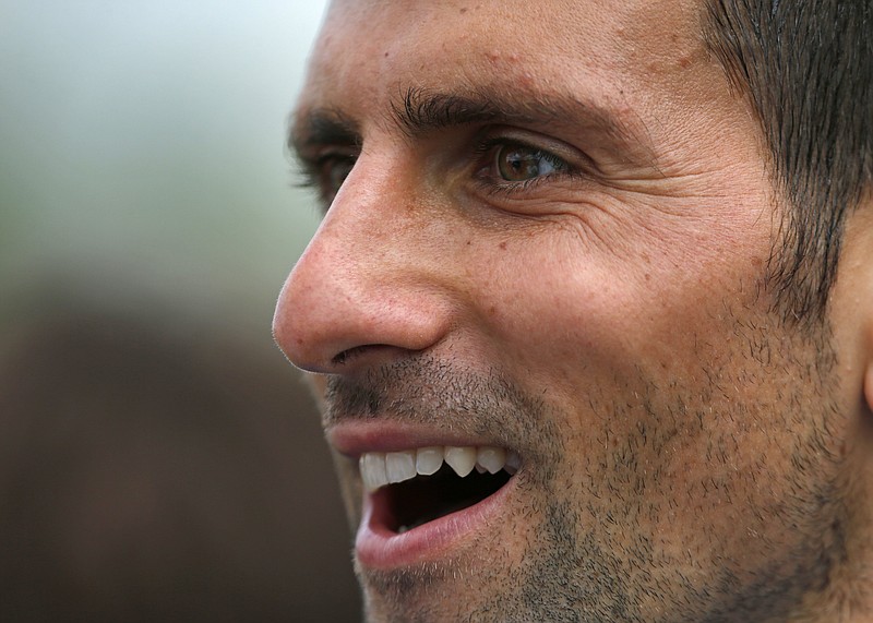 
              Novak Djokovic of Serbia smiles after completing a training session the day before the Wimbledon Tennis Championships in London,  Sunday, June 26, 2016. (AP Photo/Ben Curtis)
            