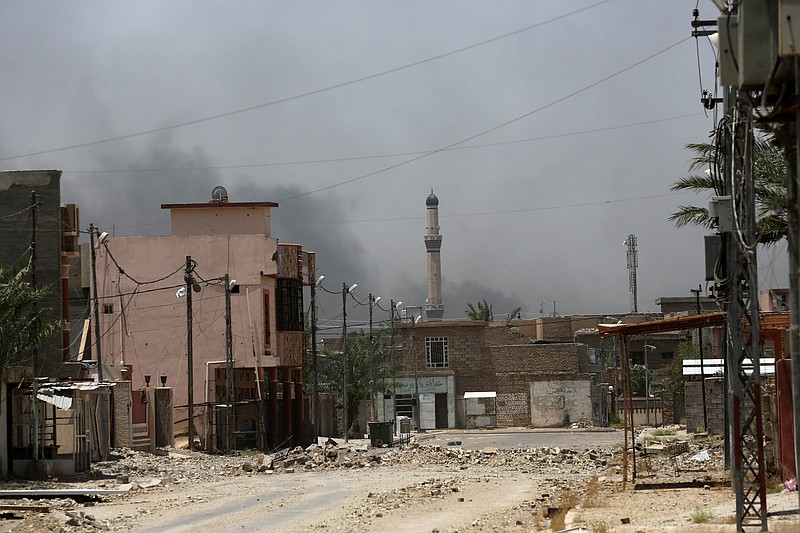 
              Rubble fills a street in Fallujah, Iraq, Monday, June 27, 2016. Thick clouds of black smoke billowed over the Julan neighborhood in northwest Fallujah Monday as dozens of homes continued to burn a day after the city was declared “fully liberated” from the Islamic State group. Iraqi special forces Lt. Gen. Abdel Wahab al-Saadi who led the operation to retake the city, said that IS militants torched hundreds of houses in Fallujah's north and west as they fled Sunday, just as the fighters did in many of the city's other neighborhoods over the course of the operation. (AP Photo/Hadi Mizban)
            